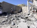 Workers stand among the rubble of the Huqah health facility 